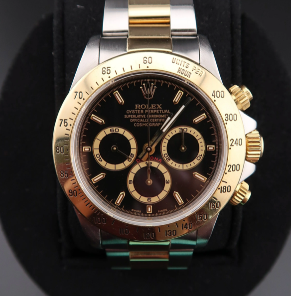 Luxury watch with a black face and gold accents on a dark background